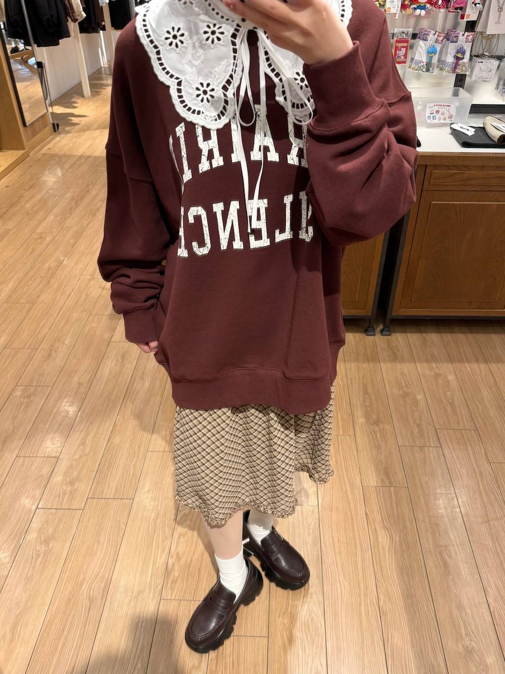 ブラウン系のローファー、ブラウン系のスウェット、ベージュ系のスカートを着用したレディースの冬コーディネートの2枚目の写真