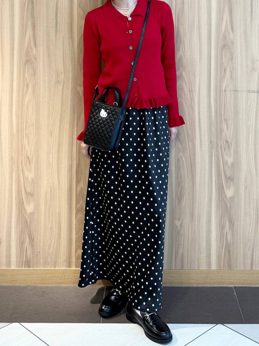 ブラック系のスカート、レッド系のニット/セーター、ブラック系のローファーを着用したレディースの秋コーディネートの5枚目の写真