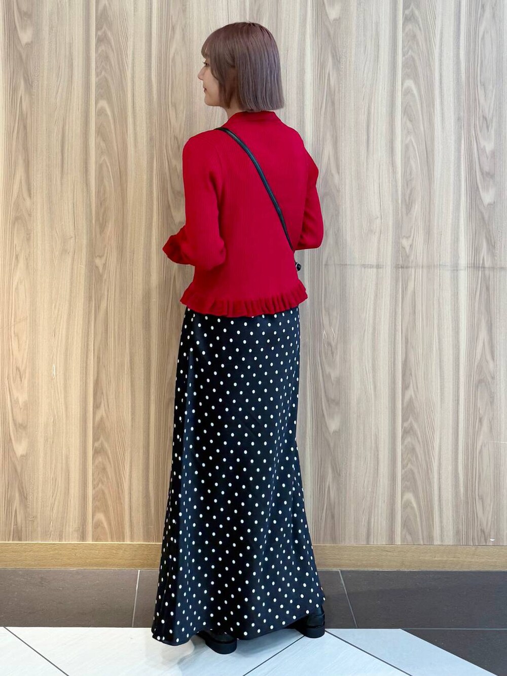 ブラック系のスカート、レッド系のニット/セーター、ブラック系のローファーを着用したレディースの秋コーディネートの3枚目の写真