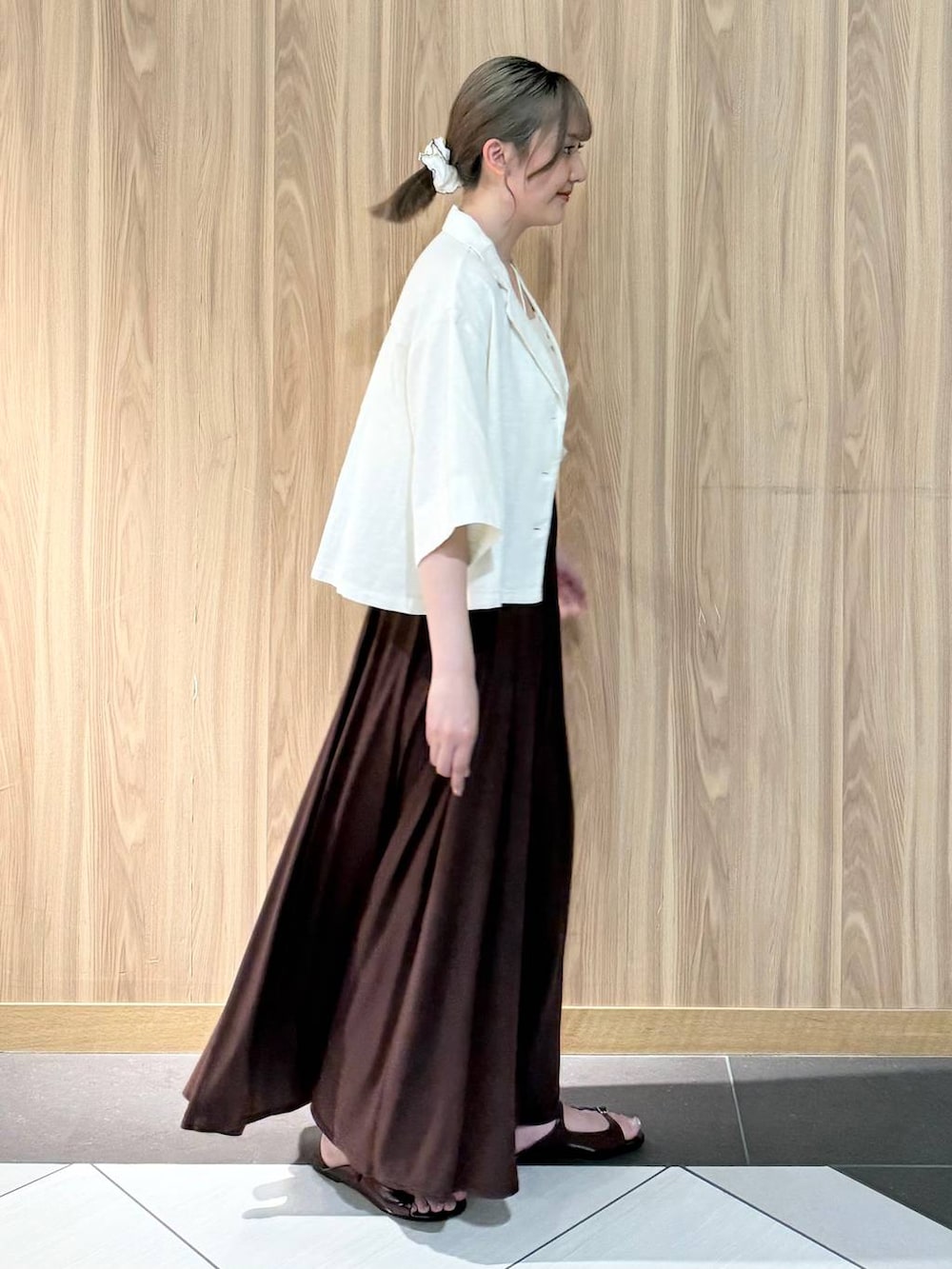 ホワイト系のシャツ/ブラウス、ブラウン系のサンダル、ブラウン系のスカートを着用したレディースの夏コーディネートの2枚目の写真
