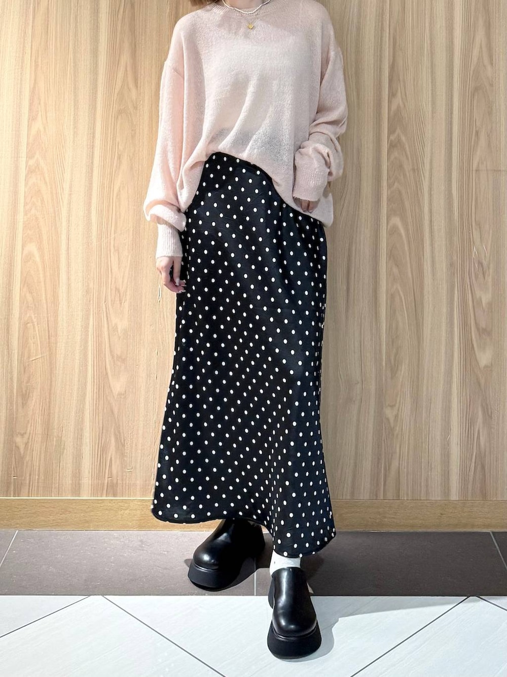 ブラック系のスカート、ブラック系のサンダル、ピンク系のニット/セーターを着用したレディースの秋コーディネートの5枚目の写真