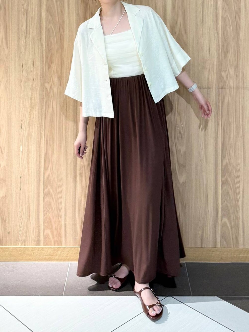 ホワイト系のシャツ/ブラウス、ブラウン系のサンダル、ブラウン系のスカートを着用したレディースの夏コーディネートの5枚目の写真