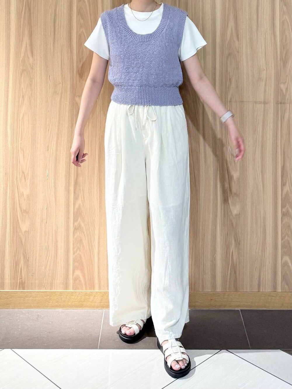ベージュ系のその他パンツ、ホワイト系のサンダル、パープル系のニット/セーターを着用したレディースの夏コーディネートの5枚目の写真