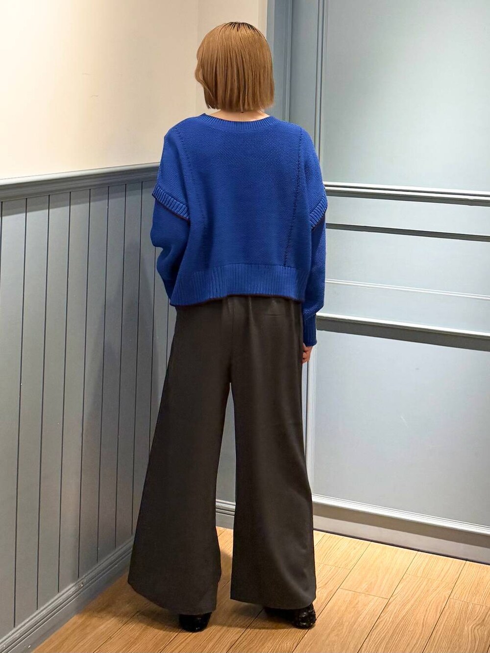 グレー系のその他パンツ、ブルー系のニット/セーターを着用したレディースの秋コーディネートの2枚目の写真