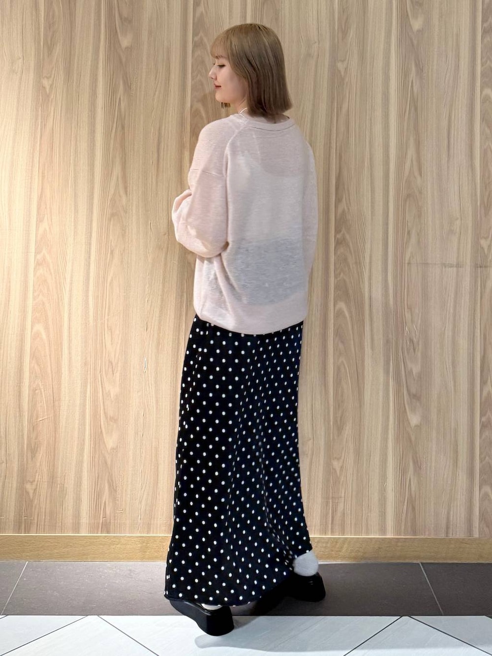 ブラック系のスカート、ブラック系のサンダル、ピンク系のニット/セーターを着用したレディースの秋コーディネートの3枚目の写真