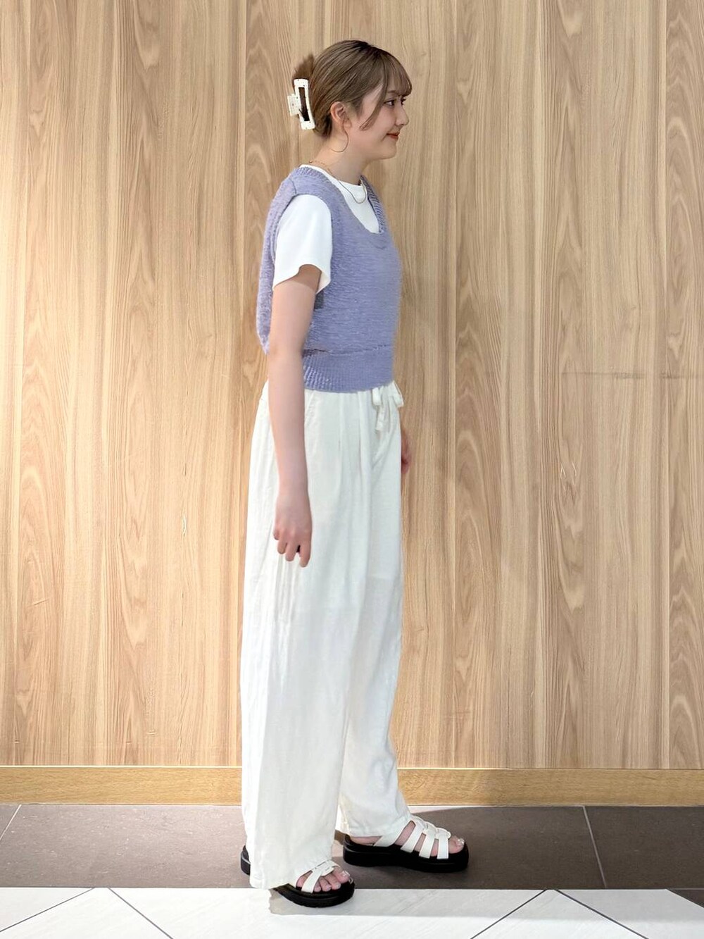 ベージュ系のその他パンツ、ホワイト系のサンダル、パープル系のニット/セーターを着用したレディースの夏コーディネートの2枚目の写真