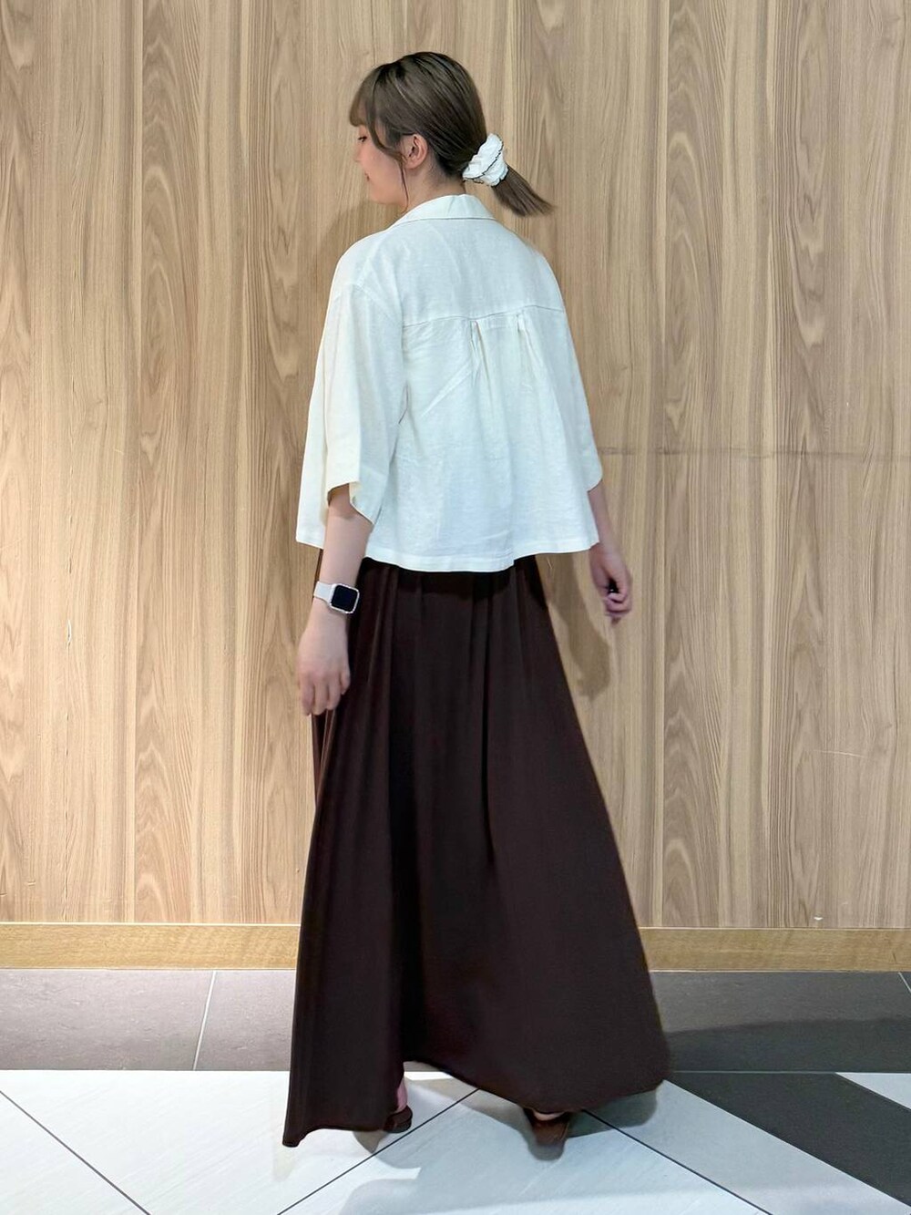 ホワイト系のシャツ/ブラウス、ブラウン系のサンダル、ブラウン系のスカートを着用したレディースの夏コーディネートの3枚目の写真