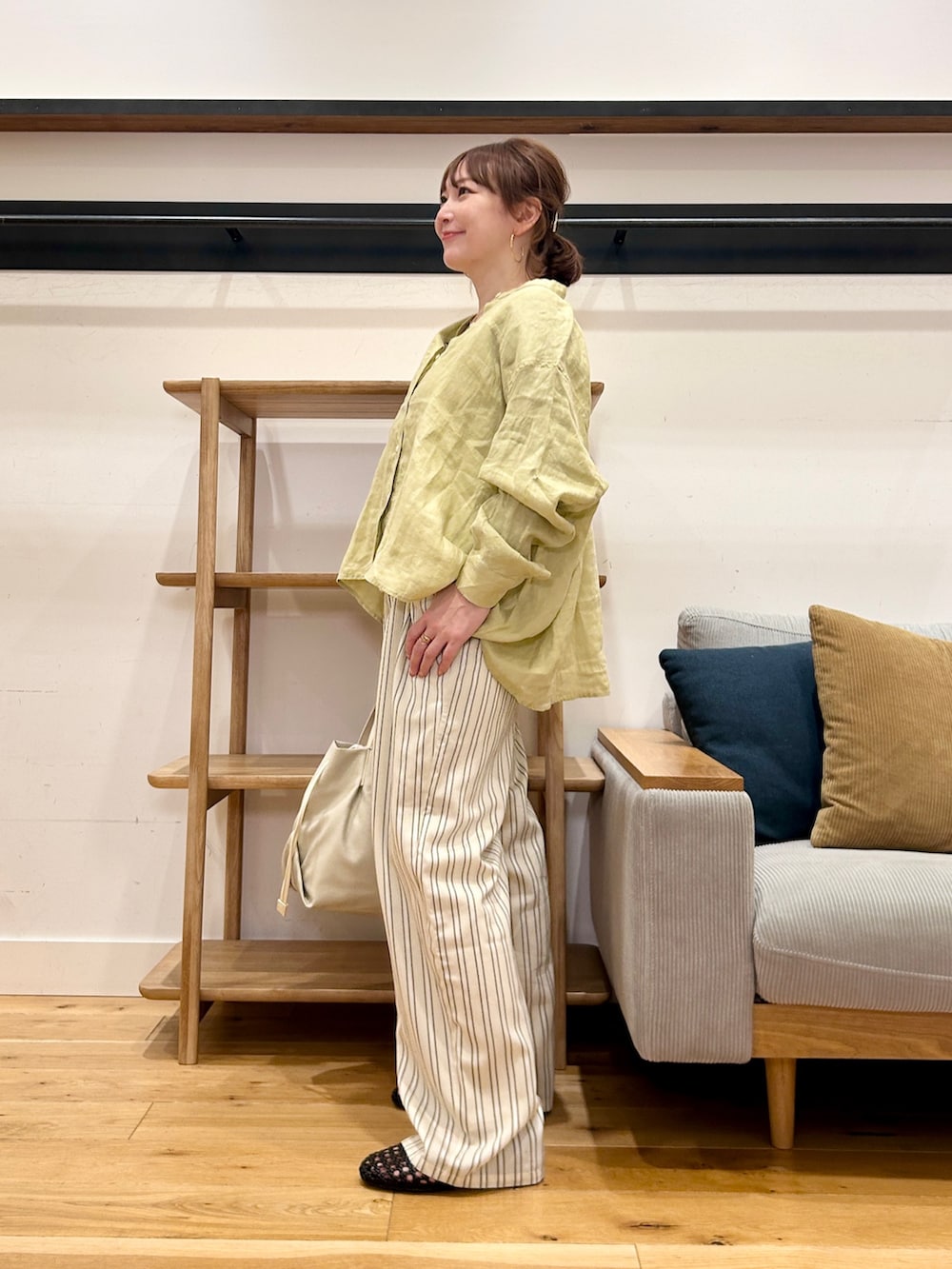 イエロー系のシャツ/ブラウス、ベージュ系のその他パンツ、ホワイト系のショルダーバッグを着用したレディースの春コーディネートの2枚目の写真