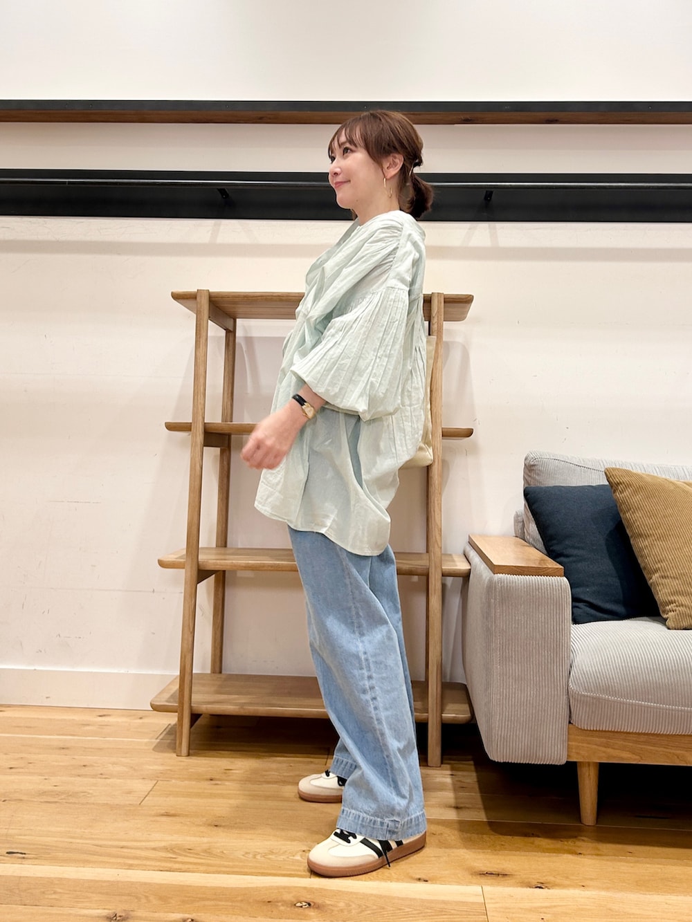 グリーン系のシャツ/ブラウス、ブルー系のデニムパンツ、ベージュ系のスニーカーを着用したレディースの春コーディネートの3枚目の写真