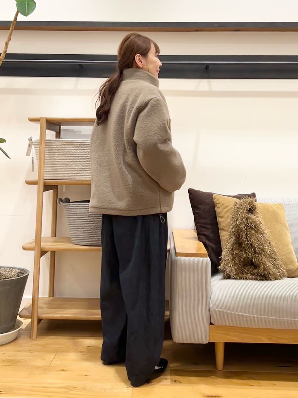 ブラウン系のニット/セーター、ブラウン系のトートバッグ、ブルー系のデニムパンツを着用したレディースの冬コーディネートの6枚目の写真