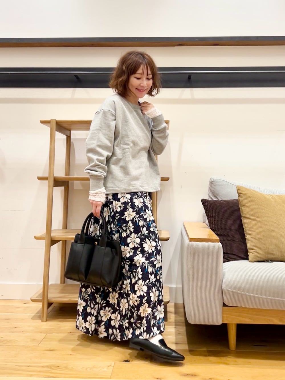 グレー系のスウェット、ブルー系のスカート、オレンジ系のトートバッグを着用したレディースの冬コーディネートの4枚目の写真