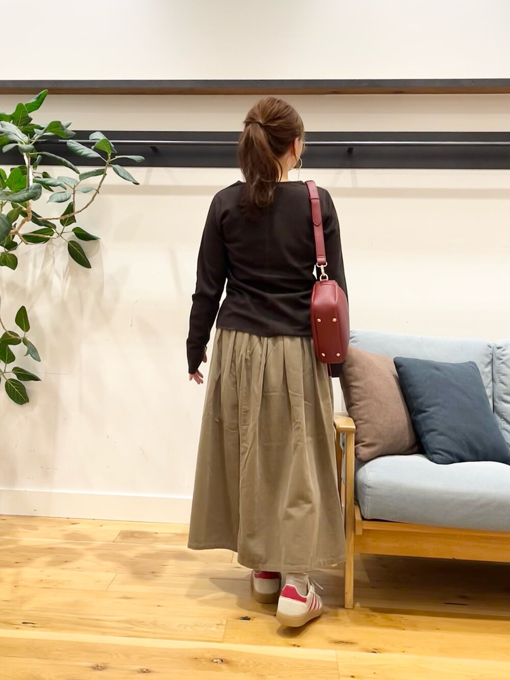 ブラウン系のTシャツ/カットソー、ベージュ系のスカート、グリーン系のショルダーバッグを着用したレディースの秋コーディネートの3枚目の写真