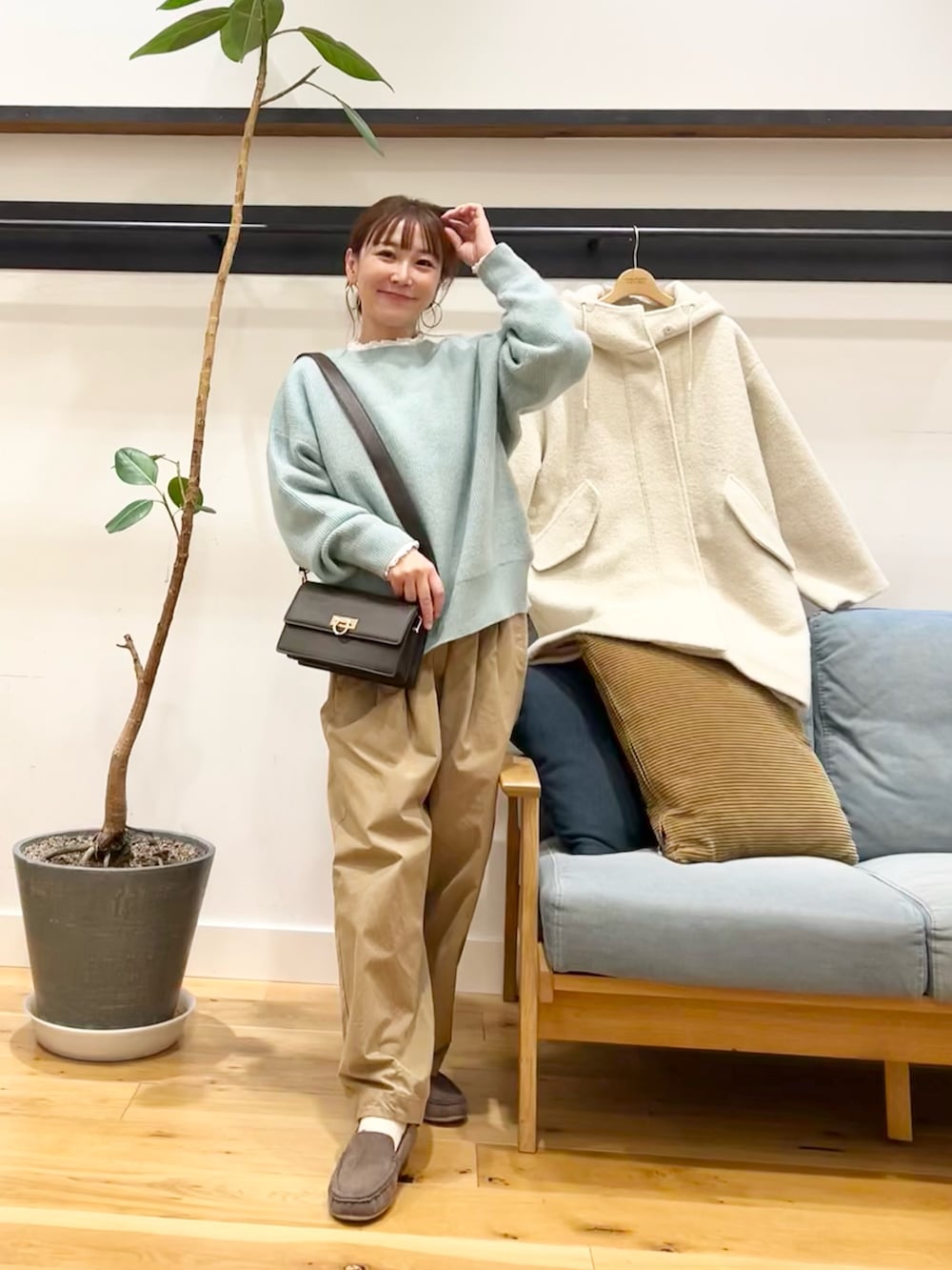 グリーン系のニット/セーター、ベージュ系のその他パンツ、ホワイト系のシャツ/ブラウスを着用したレディースの冬コーディネートの3枚目の写真
