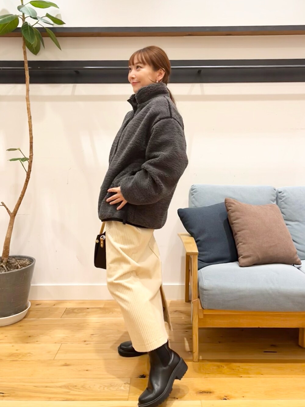 グレー系のブルゾン、ホワイト系のスカート、ブラック系のトートバッグを着用したレディースの冬コーディネートの3枚目の写真