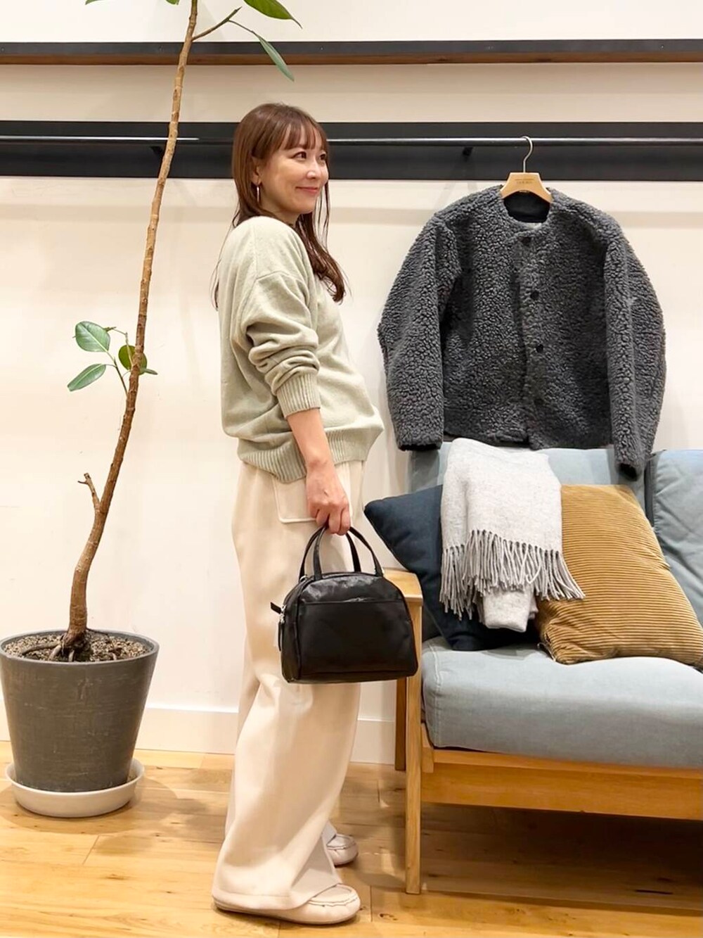 ブラック系のショルダーバッグ、グレー系のその他アウター、ホワイト系のその他パンツを着用したレディースの冬コーディネートの4枚目の写真