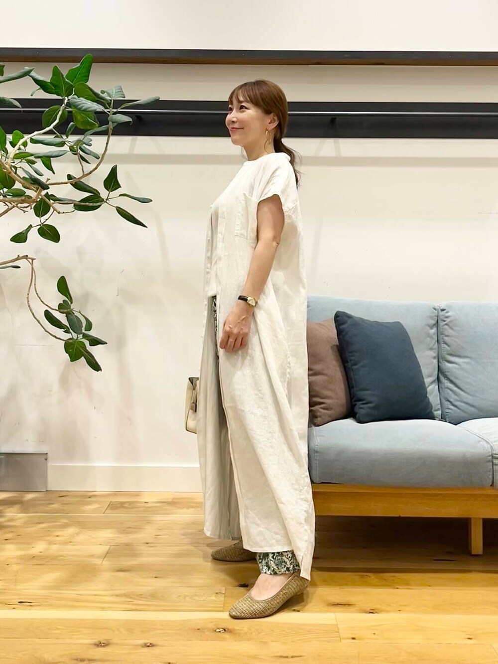 ホワイト系のハンドバッグ、ベージュ系のパンプス、ホワイト系のワンピースを着用したレディースの夏コーディネートの2枚目の写真