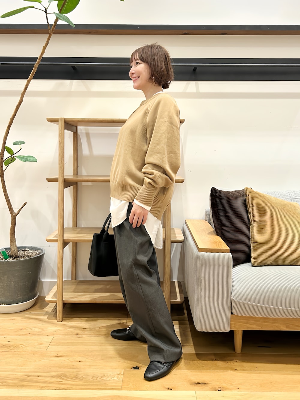 ベージュ系のニット/セーター、ホワイト系のシャツ/ブラウス、グレー系のその他パンツを着用したレディースの秋コーディネートの4枚目の写真