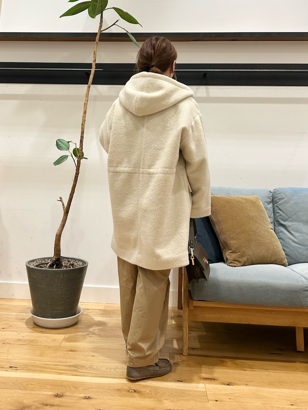 グリーン系のニット/セーター、ベージュ系のその他パンツ、ホワイト系のシャツ/ブラウスを着用したレディースの冬コーディネートの5枚目の写真