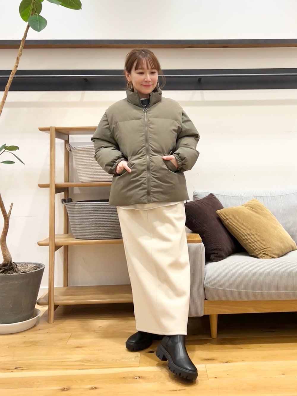 グレー系のニット/セーター、ブラウン系のトートバッグ、ホワイト系のスカートを着用したレディースの冬コーディネートの7枚目の写真