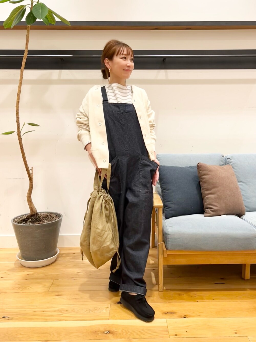 ホワイト系のカーディガン/ボレロ、ベージュ系のTシャツ/カットソー、ブルー系のオールインワン・サロペットを着用したレディースの冬コーディネートの3枚目の写真