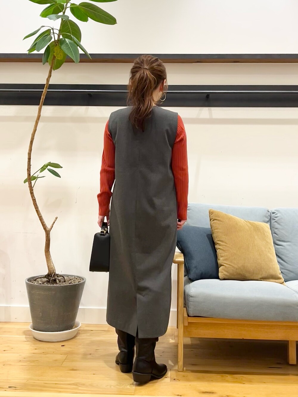 グレー系のワンピース、オレンジ系のニット/セーター、ブラック系のショルダーバッグを着用したレディースの秋コーディネートの4枚目の写真