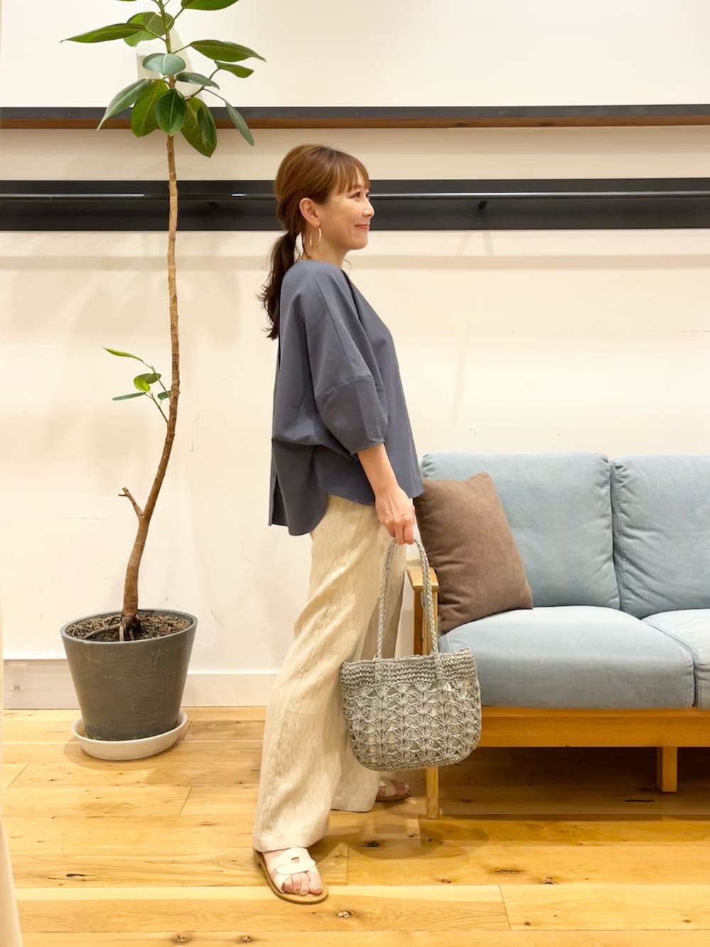 ブルー系のシャツ/ブラウス、ベージュ系のその他パンツ、グリーン系のかごバッグを着用したレディースの春コーディネートの4枚目の写真