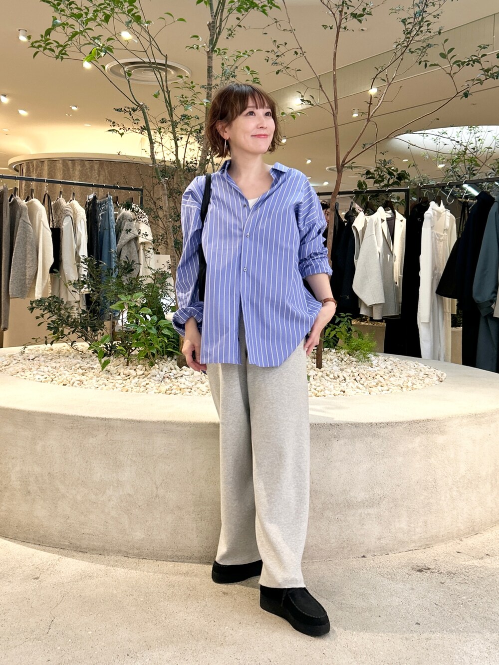 ブルー系のシャツ/ブラウス、ベージュ系のその他パンツ、ブラック系のトートバッグを着用したレディースの秋コーディネートの5枚目の写真