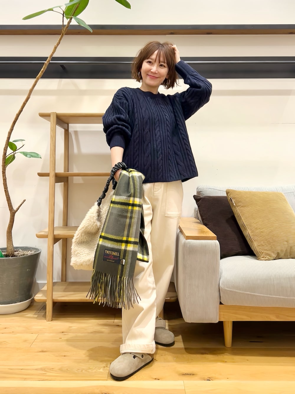 ブルー系のニット/セーター、ホワイト系のその他パンツ、ホワイト系のトートバッグを着用したレディースの秋コーディネートの4枚目の写真