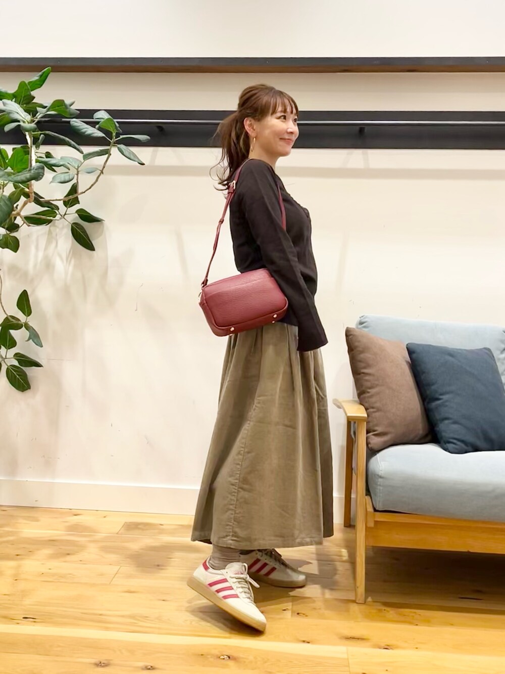 ブラウン系のTシャツ/カットソー、ベージュ系のスカート、グリーン系のショルダーバッグを着用したレディースの秋コーディネートの4枚目の写真
