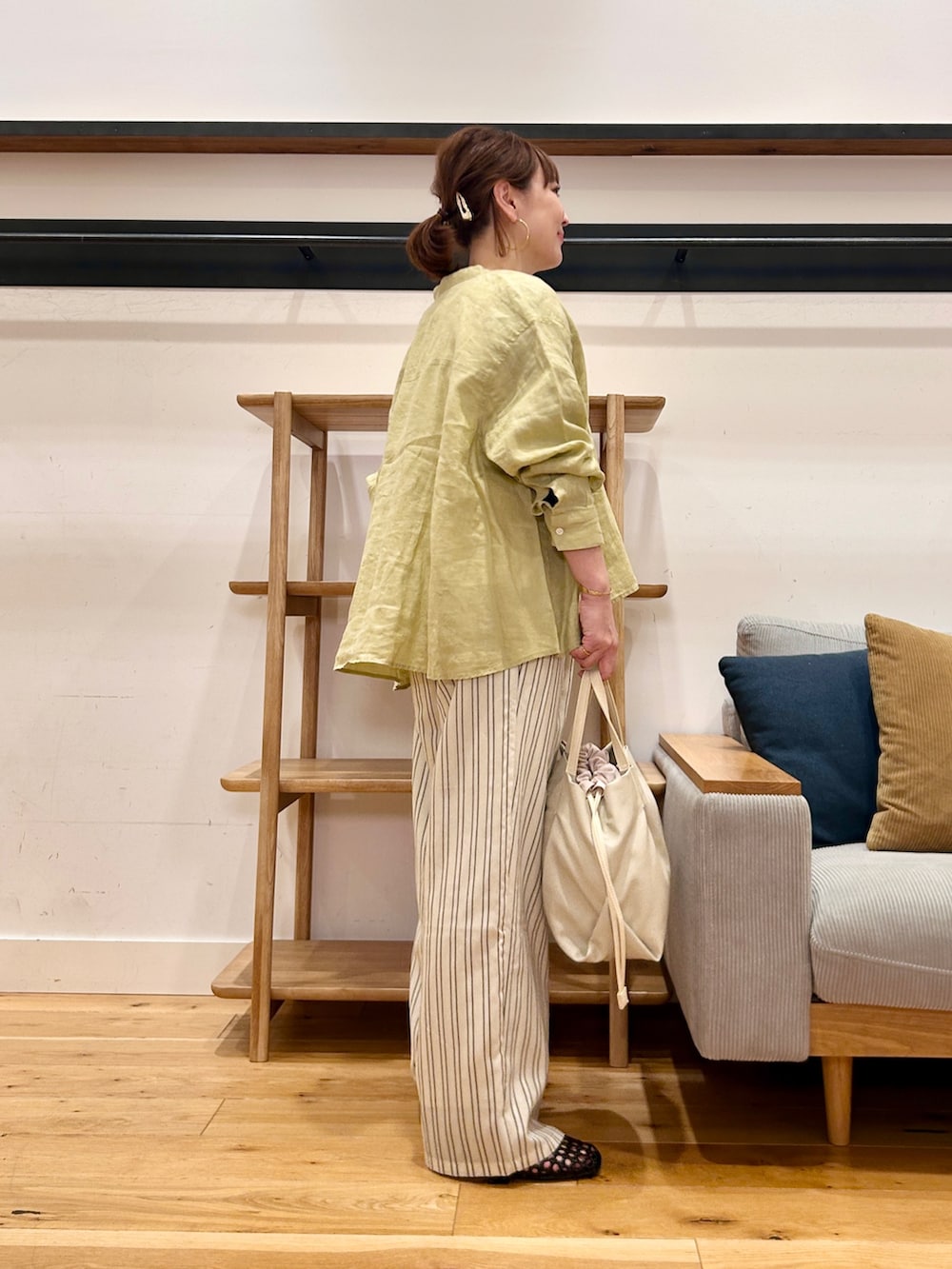 イエロー系のシャツ/ブラウス、ベージュ系のその他パンツ、ホワイト系のショルダーバッグを着用したレディースの春コーディネートの3枚目の写真