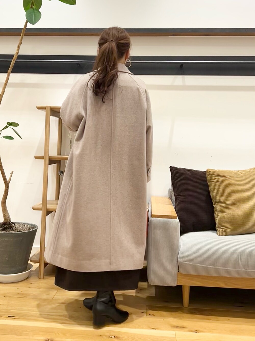 ブラウン系のワンピース、ブラック系のハンドバッグ、ブラック系のブーツを着用したレディースの冬コーディネートの7枚目の写真