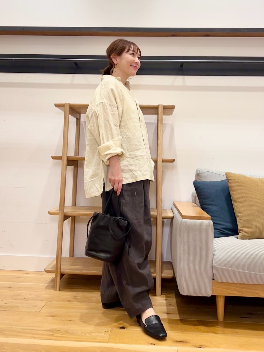 イエロー系のシャツ/ブラウス、グレー系のその他パンツ、ブラック系のショルダーバッグを着用したレディースの春コーディネートの3枚目の写真