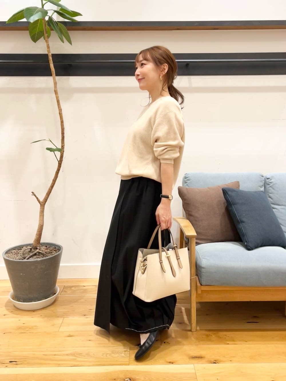 ホワイト系のニット/セーター、ブラック系のスカート、ホワイト系のトートバッグを着用したレディースの冬コーディネートの4枚目の写真