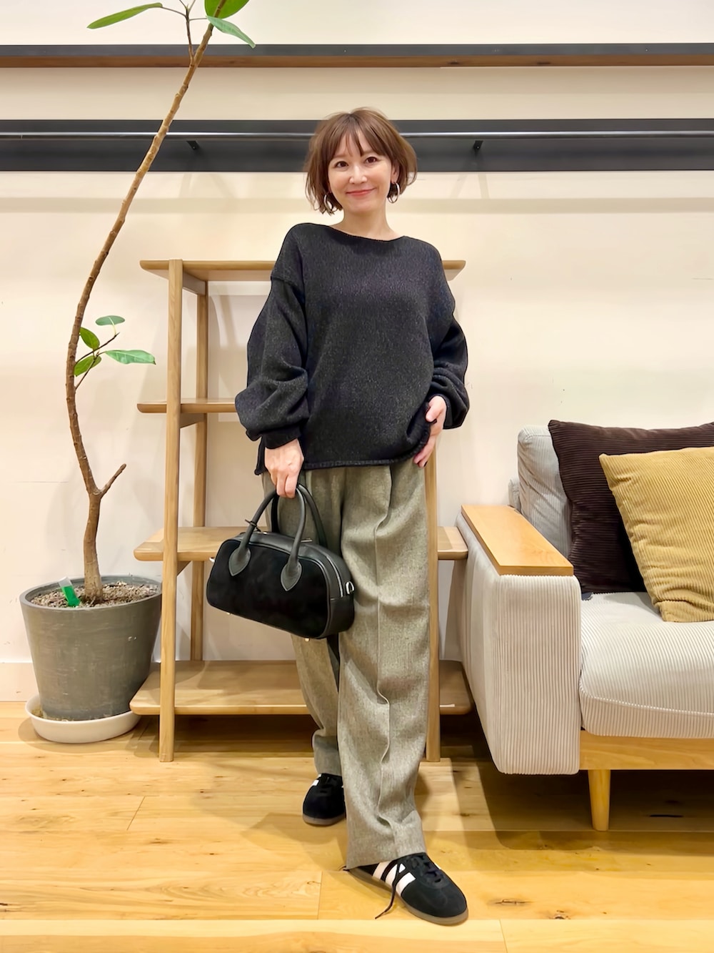 ブラック系のニット/セーター、ブラック系のショルダーバッグ、グレー系のその他パンツを着用したレディースの秋コーディネートの5枚目の写真