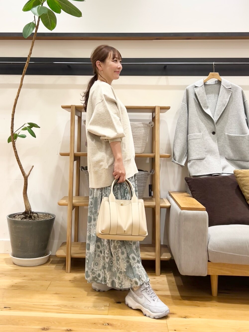 ベージュ系のスウェット、グリーン系のスカート、グレー系のトートバッグを着用したレディースの冬コーディネートの2枚目の写真