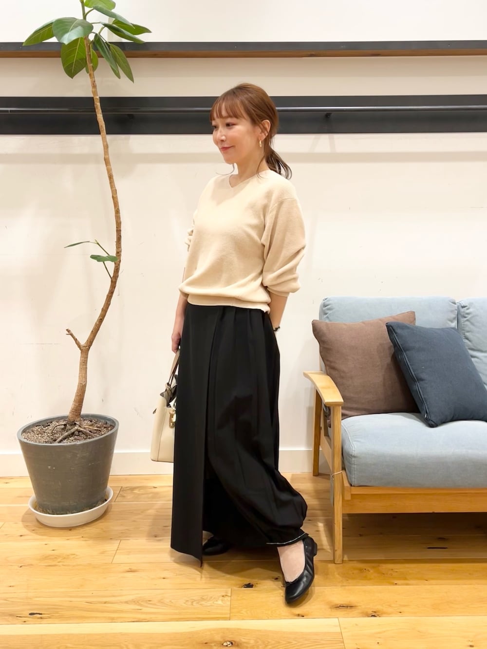 ホワイト系のニット/セーター、ブラック系のスカート、ホワイト系のトートバッグを着用したレディースの冬コーディネートの2枚目の写真