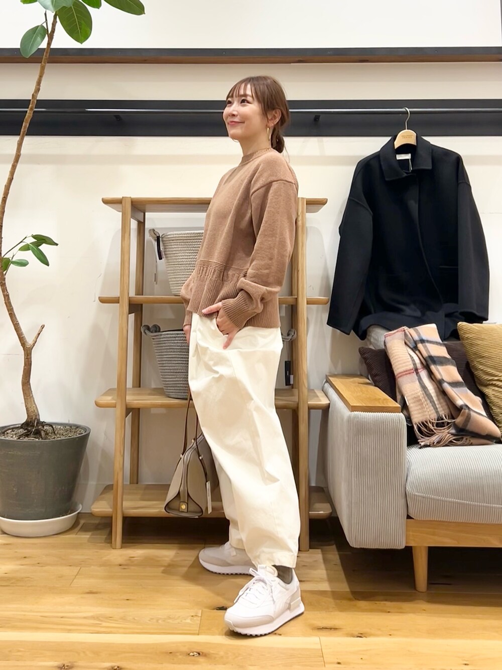 ベージュ系のニット/セーター、ホワイト系のその他パンツ、ブラック系のボストンバッグを着用したレディースの冬コーディネートの2枚目の写真