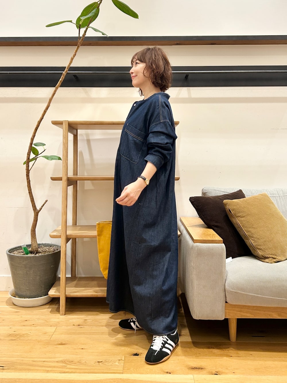 ブルー系のワンピース、オレンジ系のトートバッグ、ブラック系のスニーカーを着用したレディースの秋コーディネートの2枚目の写真