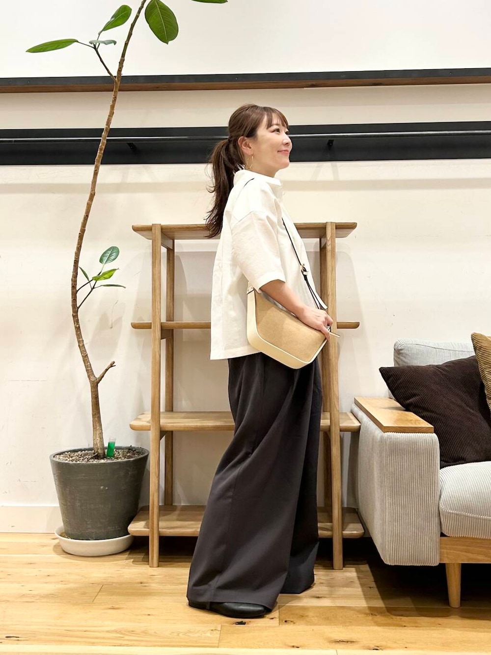 ブラック系のパンプス、ホワイト系のショルダーバッグ、グレー系のその他パンツを着用したレディースの春コーディネートの2枚目の写真