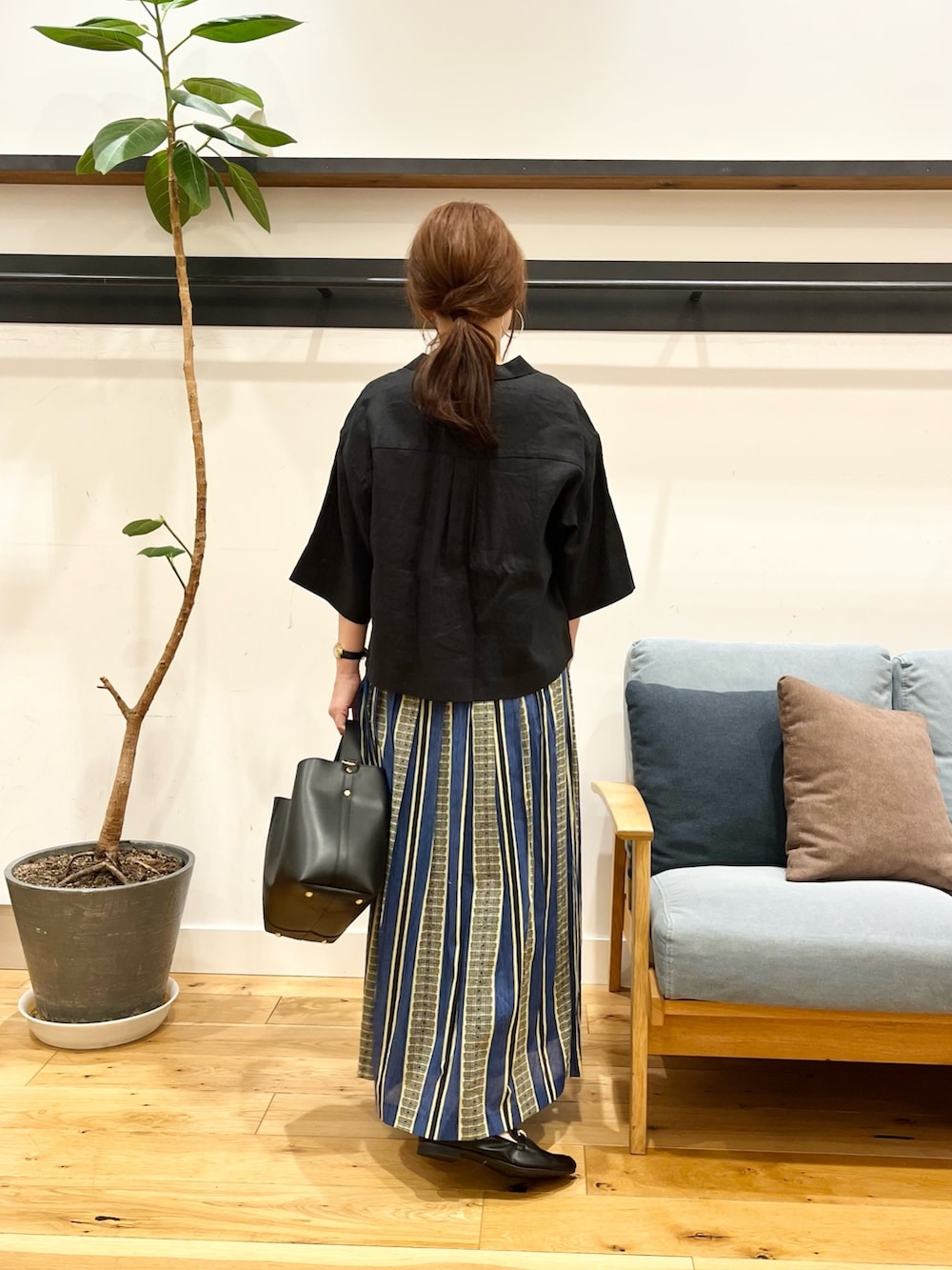 ブラック系のシャツ/ブラウス、グリーン系のスカート、ブラック系のトートバッグを着用したレディースの春コーディネートの3枚目の写真