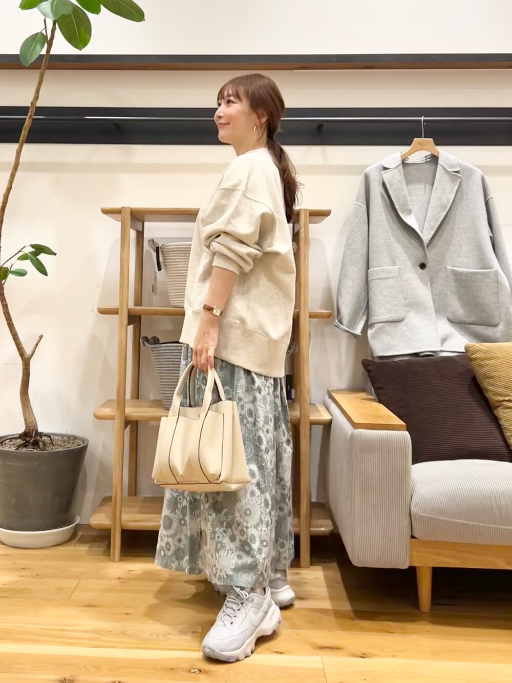 ベージュ系のスウェット、グリーン系のスカート、グレー系のトートバッグを着用したレディースの冬コーディネートの3枚目の写真