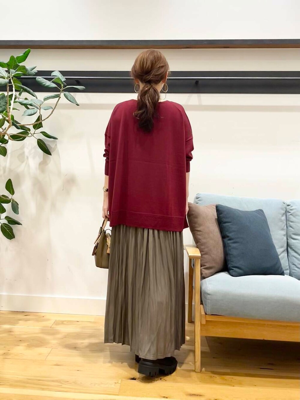 ブラック系のブーツ、レッド系のニット/セーター、ブラウン系のハンドバッグを着用したレディースの秋コーディネートの5枚目の写真