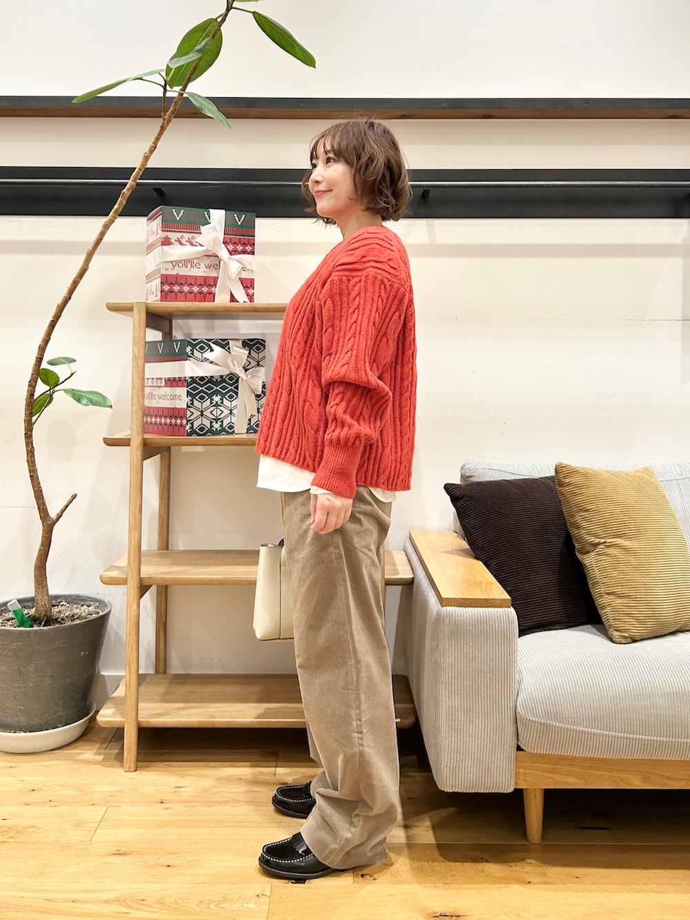 オレンジ系のニット/セーター、ホワイト系のTシャツ/カットソー、ベージュ系のその他パンツを着用したレディースの冬コーディネートの2枚目の写真