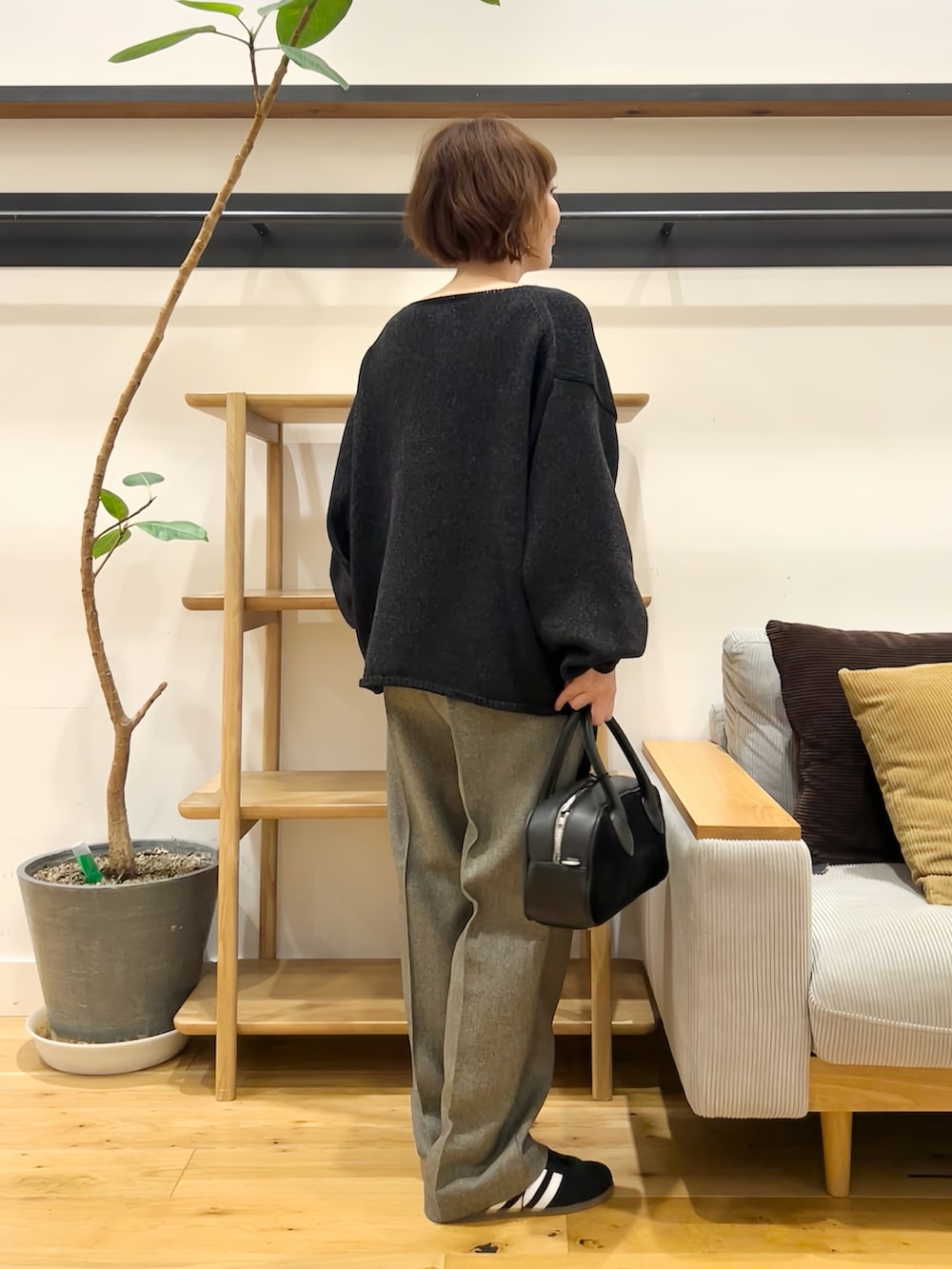 ブラック系のニット/セーター、ブラック系のショルダーバッグ、グレー系のその他パンツを着用したレディースの秋コーディネートの4枚目の写真