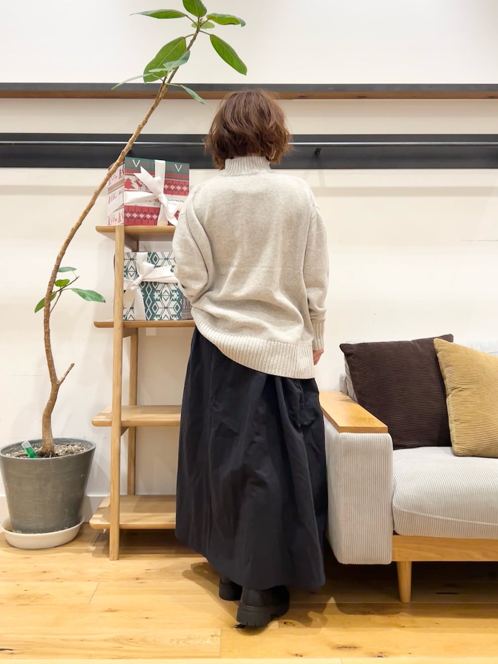 グレー系のニット/セーター、ブルー系のスカート、ブラック系のブーツを着用したレディースの冬コーディネートの4枚目の写真