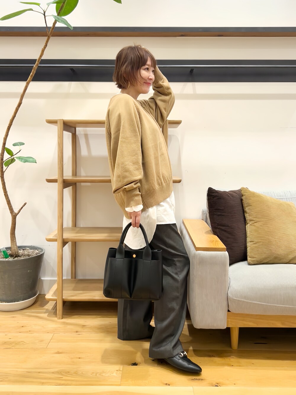 ベージュ系のニット/セーター、ホワイト系のシャツ/ブラウス、グレー系のその他パンツを着用したレディースの秋コーディネートの2枚目の写真