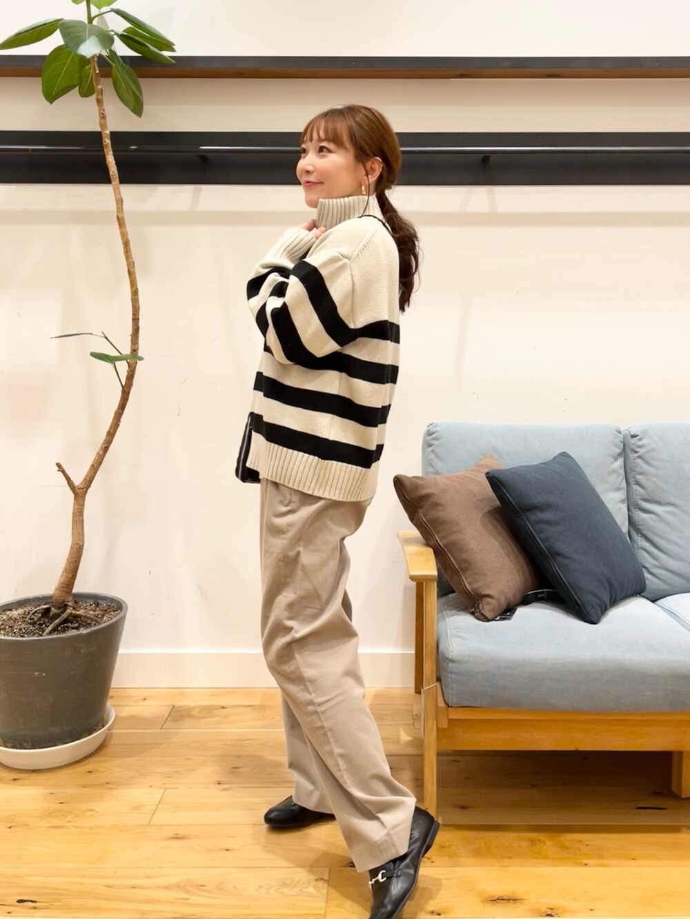 ホワイト系のニット/セーター、ブラック系のショルダーバッグ、ベージュ系のその他パンツを着用したレディースの冬コーディネートの2枚目の写真