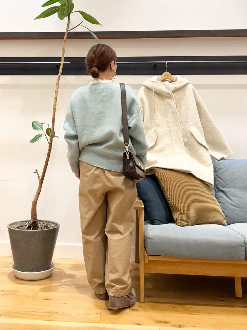 グリーン系のニット/セーター、ベージュ系のその他パンツ、ホワイト系のシャツ/ブラウスを着用したレディースの冬コーディネートの4枚目の写真