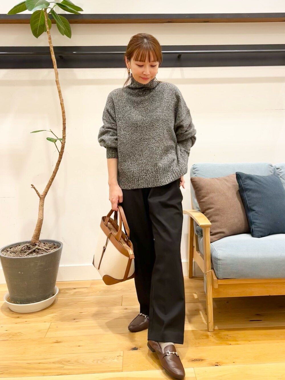 グレー系のニット/セーター、ブラック系のその他パンツ、ブラウン系のローファーを着用したレディースの冬コーディネートの4枚目の写真