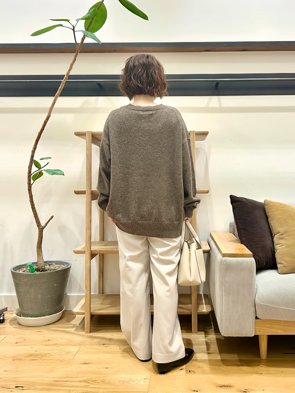 ブラウン系のニット/セーター、グレー系のその他パンツ、オレンジ系のトートバッグを着用したレディースの秋コーディネートの3枚目の写真
